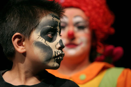A boy shows off his face painted by a clown during the International Clown Convention in Mexico City October 17, 2006.