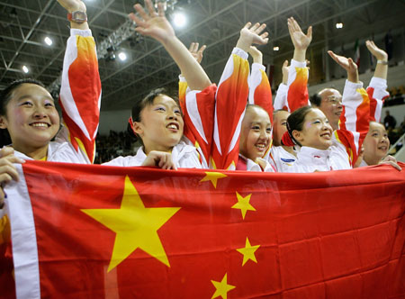 Members of the Chinese gymnastics team hold their flag as they celebrate their gold medal win in the team event at the Artistic Gymnastics World Championships in Aarhus, Denmark October 18, 2006. Team China were followed by silver medal winners USA and bronze medallists Russia. 
