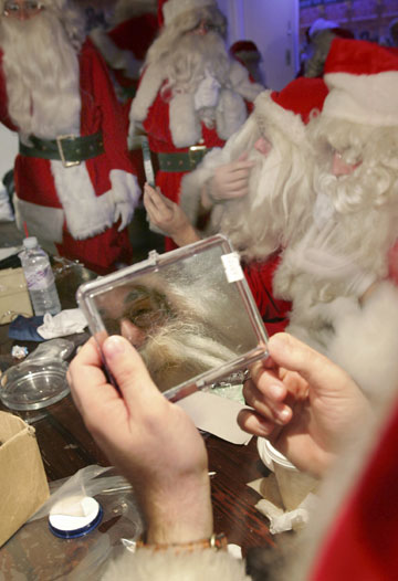 Santas get dressed during a day of teaching in central London October 30, 2006. The professional Father Christmases attended the annual training day on Monday before they are employed during the Christmas period.