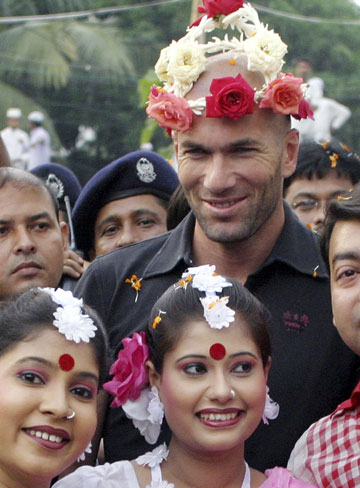 French soccer player Zinedine Zidane poses with dancers at the Bangladesh football federation in Dhaka, November 7, 2006. Zidane received a rousing welcome when he played football with children in a dusty Bangladeshi village on Tuesday.