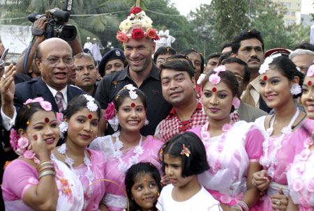 French soccer player Zinedine Zidane (C) is surrounded by young players at the Bangladesh football federation in Dhaka, November 7, 2006. Zidane received a rousing welcome when he played football with children in a dusty Bangladeshi village on Tuesday.
