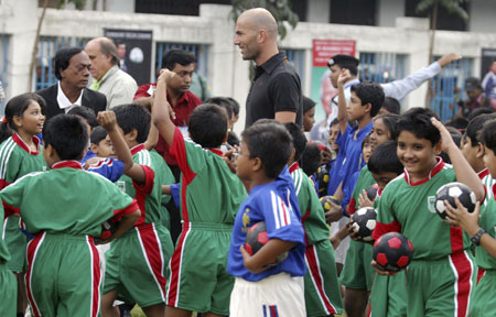 French soccer player Zinedine Zidane (C) is received by dancers at the Bangladesh football federation in Dhaka, November 7, 2006. Zidane received a rousing welcome when he played football with children in a dusty Bangladeshi village on Tuesday.