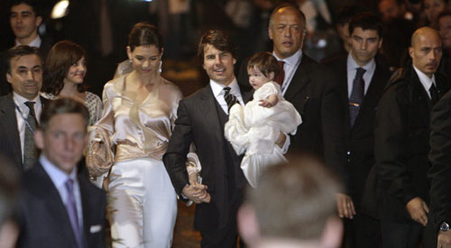 Actor Tom Cruise holds his daughter Suri as he arrives with his fiancee Katie Holmes (centre, L) to a restaurant in Rome November 16, 2006.