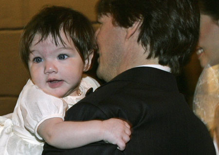 Actor Tom Cruise holds his daughter Suri as he arrives with his fiancee Katie Holmes (R) at a restaurant in Rome November 16, 2006.