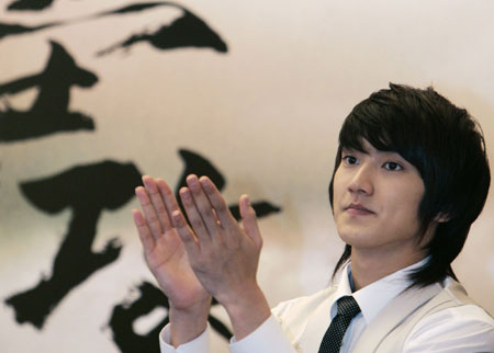 South Korean actor Choi Si Won applauds as he attends a news conference on his latest movie 