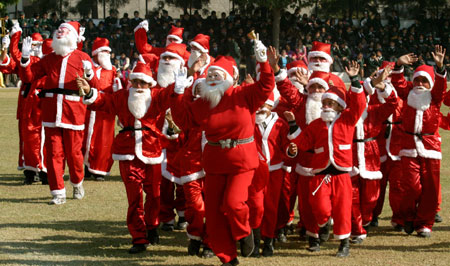 School children dressed as Santa Claus perform during a cultural programme at a school in the northern Indian city of Chandigarh December 18, 2006. Christmas is a popular festival in India and is celebrated widely across the country by people of all faiths.