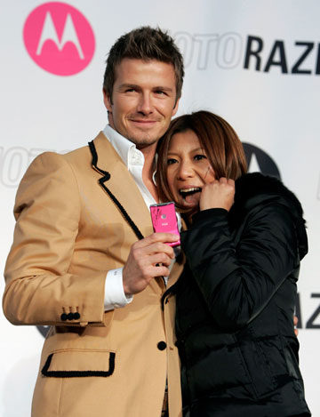 Soccer player David Beckham (L) of England poses with a Japanese fan at a promotional event in Tokyo December 29, 2006.