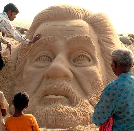 Indian sand artist Sudarshan Patnaik (top L) makes a sand sculpture of executed former Iraqi President Saddam Hussein in Puri, the eastern coast of the Indian state of Orissa, December 30, 2006.