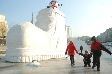 A man walks along an ice sculpture modelled after a shoe for the upcoming the China Harbin international ice and snow festival in Harbin, northeastern China's Heilongjiang Province, January 4, 2007.