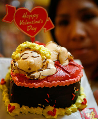 A worker displays a cake sample for Valentine's Day at the Kink Cake store in Manila's Makati financial district February 12, 2007. Kink Cakes sells 