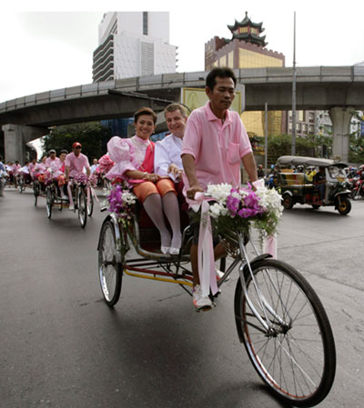 Newly wedded couples take part in a parade on tricycles after receiving marriage certificates on St. Valentine's Day in Bangkok February 14, 2007. Twenty-six couples on Wednesday went to the Bangrak (District of Love) government office to register their marriages. 