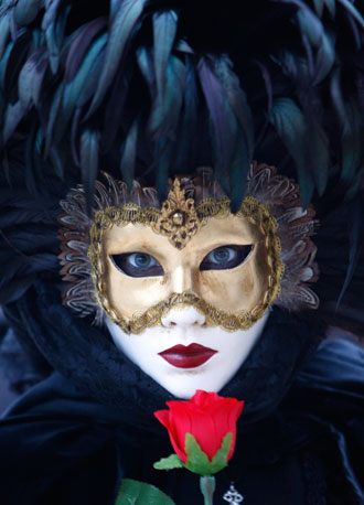 A woman wears a mask while posing for tourists in Saint Mark's square during the carnival in Venice February 14, 2007. The canal city expects to attract 1.2 million people during the 12 days of carnival, 20 percent more than last year and vastly outnumbering the 62,000 residents of the city's historical centre.