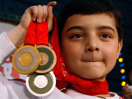 Chinese child performer Aerfa from Xinjiang displays Beijing Olympic medals after the medal launching ceremony in Beijing March 27, 2007. The launching of the medals coincided with the 500 day countdown to the Olympic Games in China's capital which will fall on August 8, 2008.