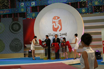 Assistant Director of the General Administration of sports of China Cai Zhenhua, BOCOG's executive vice president Jiang Xiaoyu and Deng Yaping, a former table tennis Olympic gold medallist (L-R) unveil the Beijing Olympic medals during the launching ceremony in Beijing March 27,2007.