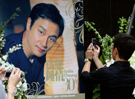 A fan uses his mobile phone to take photos of the portrait of the late Hong Kong superstar Leslie Cheung outside the hotel, where Cheung committed suicide, in Hong Kong April 1, 2007. Sunday marked the fourth anniversary of Cheung's suicide. Cheung, one of Asia's most enduring stars, died at the age of 46 and left behind a suicide note widely believed to have revealed emotional problems. 