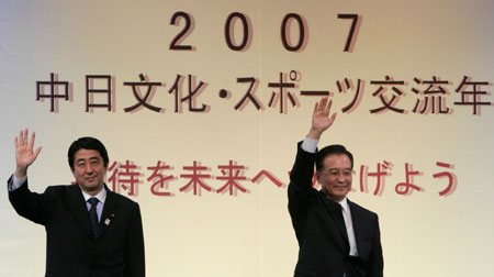Chinese Premier Wen Jiabao (R) and Japanese Prime Minister Shinzo Abe wave to the audience as they attend an event of the 2007 Japan-China Culture and Sports Exchange Year at the National Theatre in Tokyo April 12, 2007.