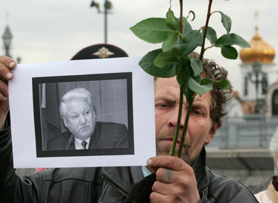 A man holds a portrait of the late former Russian President Boris Yeltsin as he stands in line to pay his last respects at Yeltsin's coffin on display at the Christ the Saviour Cathedral in Moscow April 24, 2007. Russians were to pay their last respect to Yeltsin on Tuesday before a state funeral for the man who dismantled the Soviet Union and led Russia in its first chaotic years of independence. 