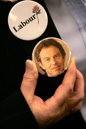 A Supporter of Britain's Prime Minister Tony Blair adjusts a badge ahead of his speech at the Trimdon Labour club in Trimdon, northern England May 10, 2007. Blair said on Thursday he will quit on June 27, 10 years after winning power in what was hailed as a new dawn for Britain that has since been darkened by the Iraq war.