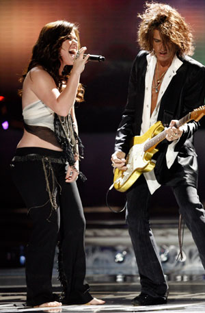 Kelly Clarkson (L) and Aerosmith's guitarist Joe Perry perform during the final of 