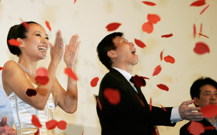 Chinese actress Zhang Ziyi (L) and movie director Feng Xiaogang react after they throw paper flowers to wish the success of their movie 