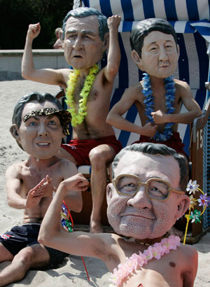 Activists of British charity organization Oxfam, wearing masks of G8 heads of state, pose on the beach in Kuehlungsborn June 7, 2007. Leaders from the world's major industrialised nations meet in the Baltic resort of Heiligendamm on June 6-8 for a Group of Eight (G8) summit. 