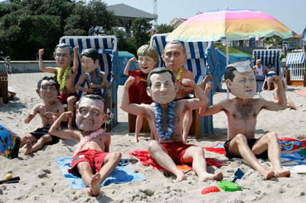 Activists of British charity organization 'Oxfam' wearing masks of the G8 heads of state, sit on the beach in Kuehlungsborn June 7, 2007. Leaders from the world's major industrialised nations meet in the Baltic resort of Heiligendamm on June 6-8 for a Group of Eight (G8) summit.