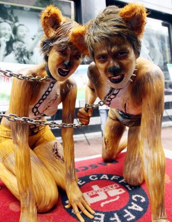 Animal rights activists, dressed up as dogs, attend a protest against the eating of dog meat in central Seoul July 25, 2007. In the summer, many Koreans traditionally eat dog meat for good health to overcome hot weather.