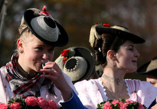 Farmers' wives dressed in traditional Bavarian costumes drink Schnapps after their ride in wooden carriages to the church of Bad Toelz during the Leonhard procession November 6, 2006. The Leonhardi Ritt procession is an annual event that started in the 17th century to pray to St. Leonhard, the patron saint of animals. 