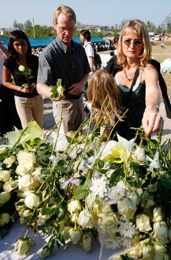 Tourists place stalks of whites roses at a memorial during a ceremony in Khao Lak, in Thailand's Phang Nga province, nearly 110 km (68 miles) north of the resort island of Phuket, marking the two-year anniversary of the Indian Ocean tsunami December 26, 2006. The Indian Ocean tsunami on December 26, 2004 killed almost 6,000 people and left nearly 3,000 missing in Thailand.