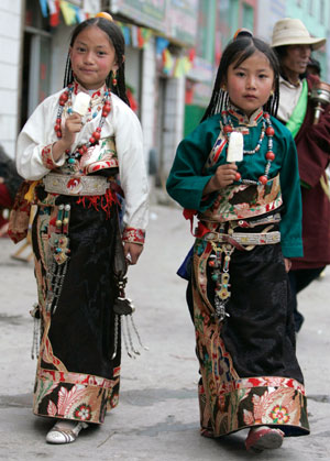 Tibetan sisters in traditional costume walk on a street in Yushu, west China's Qinghai province, July 26, 2007.