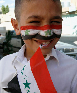A soccer fan with the colours of an Iraqi flag painted on his face smiles in Tikrit, 175 km (110 miles) north of Baghdad July 29, 2007. The final game of the 2007 AFC Asian Cup soccer tournament game between Iraq and Saudi Arabia is being held in Jakarta.