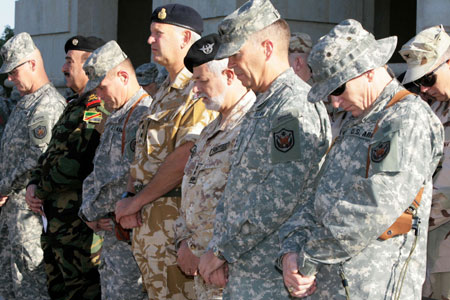 Representatives from coalition forces observe a minute of silence, during a ceremony commemorating the September 11 attacks in the U.S., at Victory Camp in the airport grounds in Baghdad September 11, 2006.
