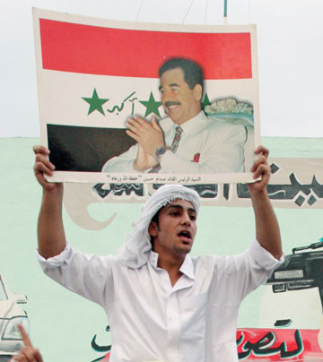 A supporter of former Iraqi leader Saddam Hussein displays his picture during a protest in reaction to the verdict against Saddam in Tikrit, 175 km (110 miles) north of Baghdad, November 5, 2006. A visibly shaken Saddam was found guilty of crimes against humanity on Sunday and sentenced to hang by the U.S.-sponsored court that has been trying him in Baghdad for the past year.