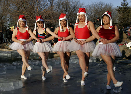 People dressed in Santa Claus costumes dance as they celebrate the upcoming Christmas Day at a park in Shenyang, capital of northeast China's Liaoning province December 23, 2006.