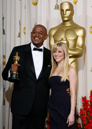 U.S. actor Forest Whitaker (L) poses with presenter Reese Witherspoon after winning an Oscar for Best Actor in a Leading Role for 