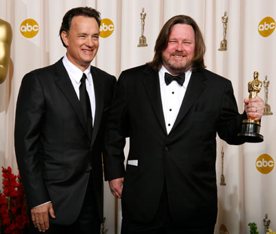 William Monahan (R) holds his Oscar for best adapted screenplay for 'The Departed' next to presenter Tom Hanks at the 79th Annual Academy Awards in Hollywood, California, February 25, 2007.