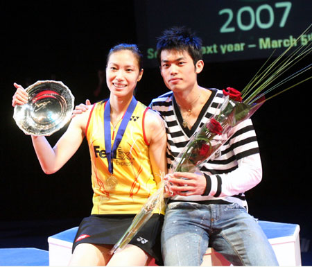 China's Xie Xingfang poses with China's Lin Dan after beating France's Pi Hongyan in the women's singles final at the All England badminton championships in Birmingham, England March 11, 2007.