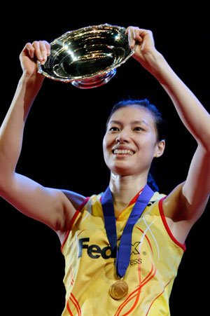 China's Xie Xingfang holds up her trophy after beating France's Pi Hongyan in the women's singles final at the All England badminton championships in Birmingham, England March 11, 2007. 