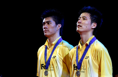 China's Cai Yun (R) and Fu Haifeng show their medals after losing to Malaysia's Tan Boon Heong and Koo Kien Keat in their men's double final match at the All England badminton championships in Birmingham, England March 11, 2007.