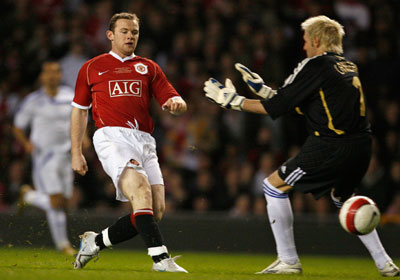 Manchester United's Wayne Rooney (L) scores past Europe XI's Santiago Canizares during a celebration soccer match to mark the 50th anniversary of Manchester United appearing in European competition at Old Trafford in Manchester, northern England, March 13, 2007. 