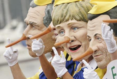 Activists from anti-globalisation organisation Oxfam dressed as U.S. President George W. Bush, German Chancellor Angela Merkel and French President Nicolas Sarkozy (L-R) in Pinocchio costume pose for the media at Rostock's harbour June 5, 2007.