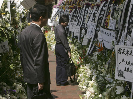 Residents walk past a row of wreaths for late billionaire tycoon Henry Fok Ying-tung's funeral outside a funeral home in Hong Kong November 7, 2006. Hong Kong's elite paid their final respects to Fok on Tuesday at the closest thing to a state funeral for one of Hong Kong's wealthiest and most powerful men.