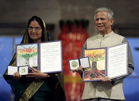 Nobel Peace Prize laureates Muhammad Yunus (R) and Grameen Bank represented by Mosammat Taslima Begum pose for photos with the Nobel medal and diploma at Oslo Town Hall December 10, 2006. 