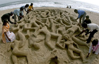 College students make a sand sculpture at Marina beach to commemorate the second anniversary of the Indian Ocean tsunami in Chennai Dec. 26, 2006.