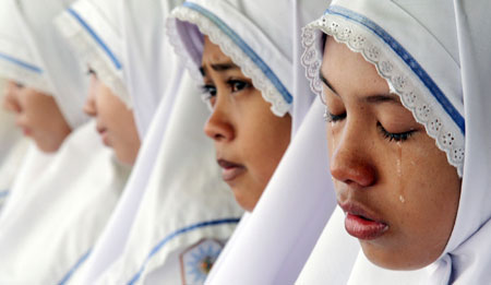 Acehnese students cry during prayers to mark the second anniversary of the Indian Ocean tsunami in Banda Aceh December 26, 2006. Thousands of people lit candles, visited mass graves and observed two minutes of silence on Tuesday two years after the unprecedented tsunami pulverised villages along the Indian Ocean and killed 230,000 people.