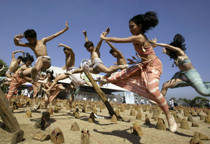 Dancers perform on an environmental art installation created with wood to symbolise illegal logging outside the Cultural Center of the Philippines to mark Earth Day in Manila April 22, 2007.