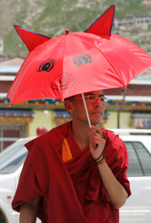 A Tibetan monk holding a novelty umbrella walks on a street in Yushu, west China's Qinghai province July 26, 2007.