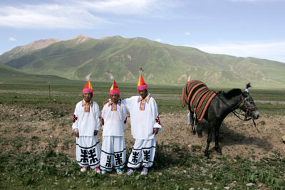 Tibetan riders pose for a photo in their traditional costumes before the traditional annual Yushu Horse Racing Festival in Yushu, west China's Qinghai province, July 26, 2007.