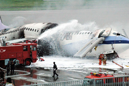 Firefighters try to extinguish fire on a plane belonging to China Airlines Ltd. that exploded and caught fire soon after landing in Naha on Japan's southern island of Okinawa August 20, 2007. All 165 people on board had escaped safely, officials said. 