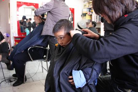 A child gets a haircut at a barbershop in Hefei